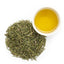 Warm clear golden liquid liquor of brewed MaHuang herbal tea in a glass cup