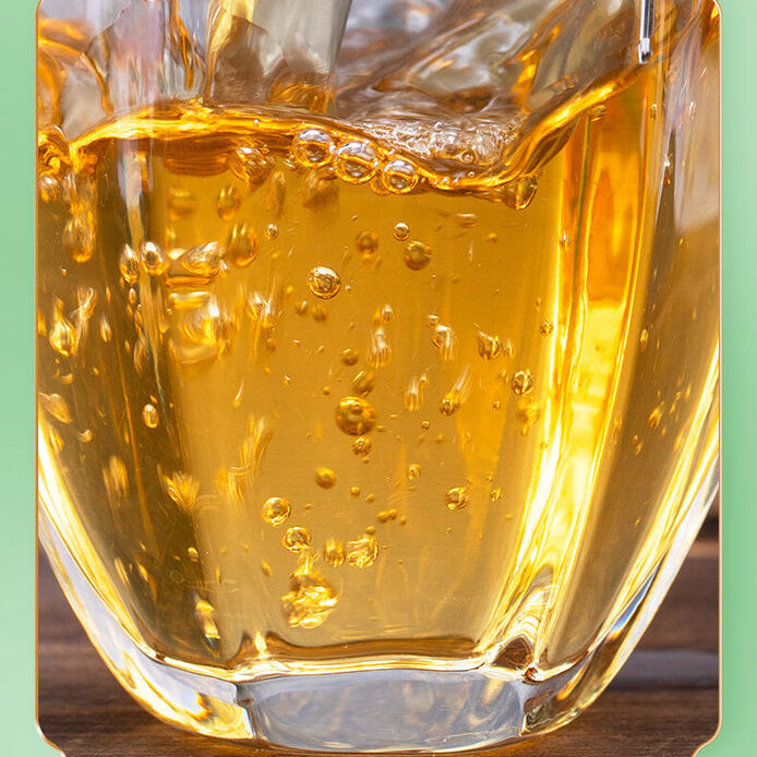 A clear glass cup filled with golden brewed Zhangping Shui Xian oolong tea, showcasing a smooth and inviting tea experience.